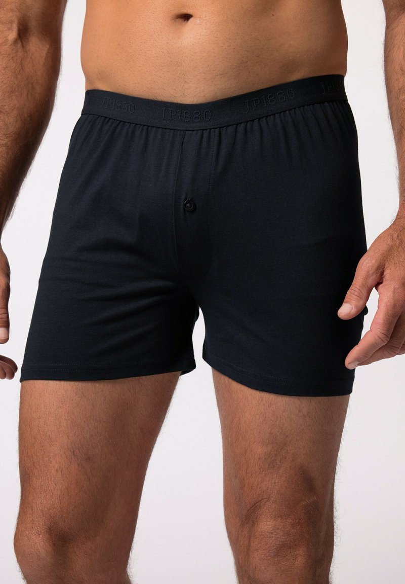 Boxer in cotone nero con elastico morbido, dotati di un bottone singolo davanti e una texture liscia.