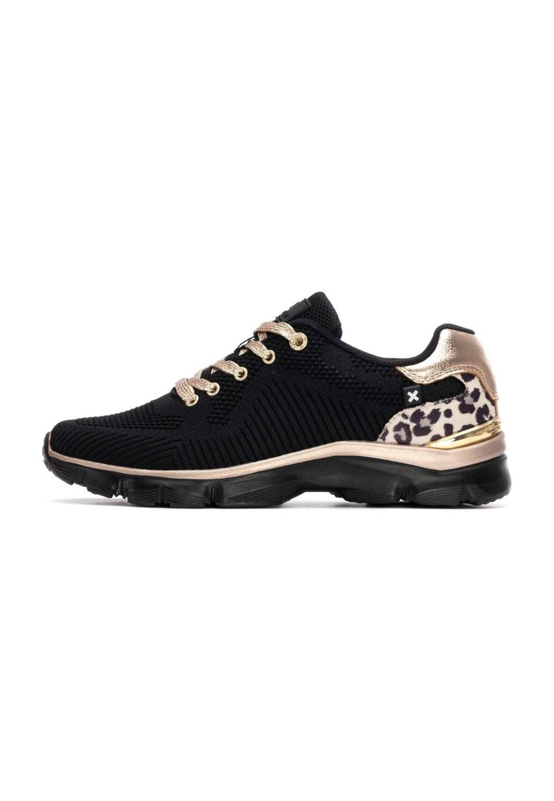 Zapatilla deportiva negra con textura trenzada, cordones dorados, acento de print de leopardo en el talón y suela acolchada para mayor comodidad.