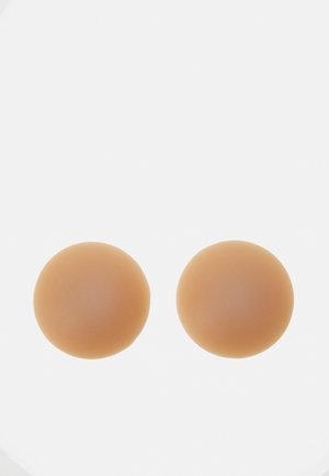Silicone breast forms, round shape, smooth texture, light tan color, designed for enhancing shape and support in clothing.