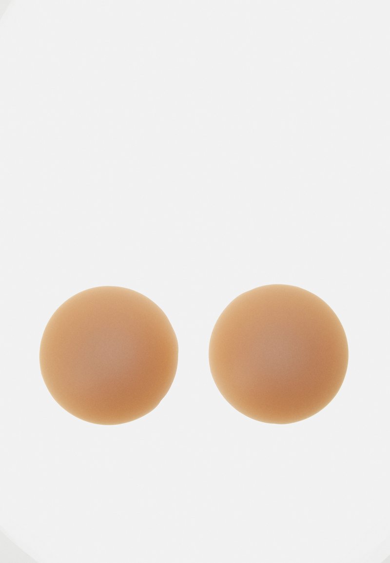 Formas de seios em silicone, de forma arredondada, textura lisa, cor beije clara, desenhadas para realçar a forma e dar apoio nas vestimentas.