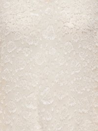 Broderat krämfärgat tyg med blommönster och texturerade detaljer. Mjuk glans och fina, upphöjda inslag skapar djup.