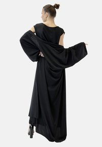 Schwarzes, fließendes Kleid mit übergroßen Ärmeln, glattem Stoff und drapiertem Design. Verfügt über einen runden Ausschnitt und eine geschichtete Rückenpartie.