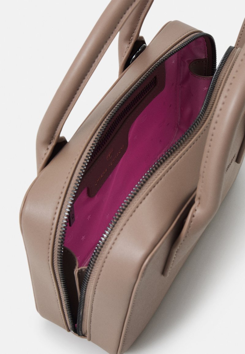 Beżowa skórzana torebka o prostokątnym kształcie, z zamknięciem na suwak i żywym różowym wnętrzem. W komplecie podwójne uchwyty.