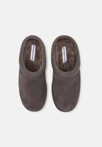 Gray slippers with a soft suede exterior and plush lining, featuring a rounded toe and elasticized collar for comfort.
