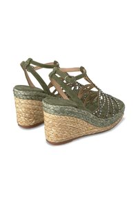 Sandali wedge in suede verde con suola in juta intrecciata, dotati di cinturini incrociati e strass decorativi.