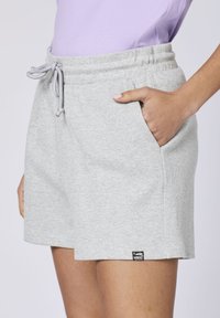 Gray shorts made from textured fabric with an elastic waistband and drawstring. Features side pockets and a small accent label.