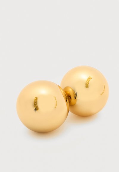 Δύο λαμπερά χρυσά σφαιρικά σκουλαρίκια συνδεδεμένα με έναν μικρό χρυσό κρίκο, με επιγραφές "MOSCHINO" και "Made in Italy" σε κάθε σφαίρα.