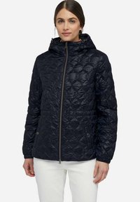 Veste matelassée bleu marine avec capuche, dotée d'une fermeture éclair sur le devant, de poignets élastiques et de deux poches latérales à fermoirs à pression. Tissu lisse et léger.