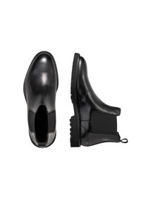 Botas de tobillo de piel negra con paneles laterales elásticos, puntera redondeada, suela texturizada y tirador en la parte trasera para facilitar el uso.