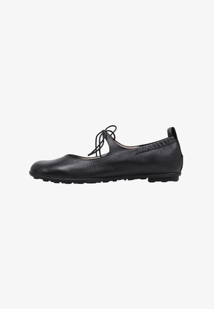 Ballerines en cuir noir avec un surface texturée, bout rond et un détail nœud à l'avant. Design à enfiler avec une semelle flexible.