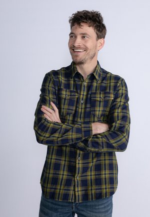 Plaid flannel shirt in navy and olive green, featuring a button-down collar, two chest pockets, long sleeves, and a relaxed fit.