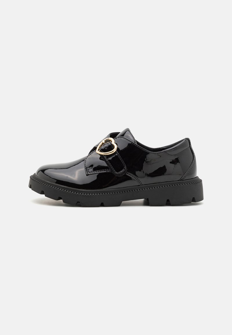 Black patent leather shoes feature a rounded toe, side buckle with heart accent, textured rubber sole, and flat heel.