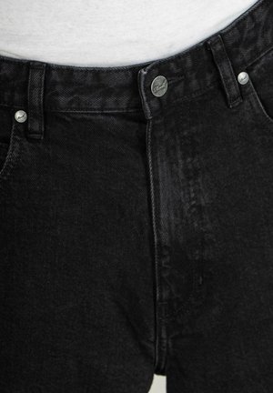 Jeans in denim nero con vita alta, chiusura frontale a bottoni, dettagli metallici argentati e una texture liscia con cuciture sottili.