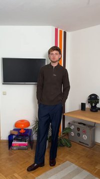 Rjav rebrast dolg rokav polo s polovičnim zadrgo, v kombinaciji s temno modrimi ožjimi hlačami in rjavimi poslovnimi čevlji. Sodobna notranjost z barvitimi akcenti.