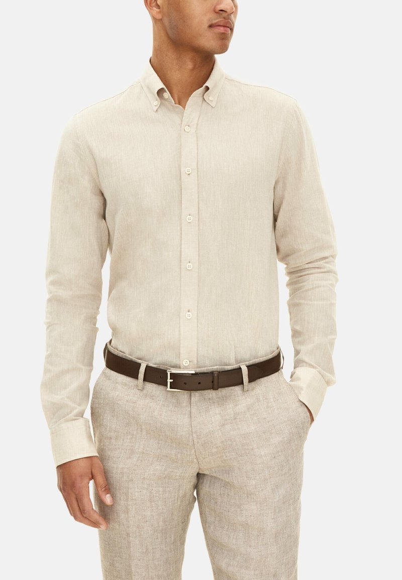 Licht beige overhemd met knopen, gemaakt van gestructureerd linnen, met een klassieke kraag en lange mouwen, gecombineerd met tan linnen broek en een bruine riem.