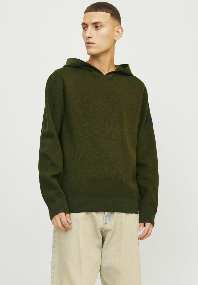 Groene gebreide hoodie met een trekkoord, met ribbelboorden en zoom. Soepele textuur, ontspannen pasvorm en subtiele branding op de mouw.
