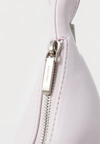 Calvin Klein handbag in light lavender leather, featuring a silver zipper with a branded pull tab and visible stitching along the seam.