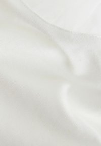 Tissu blanc avec une texture lisse, montrant des motifs tissés subtils. Drapeau doux et légère brillance dans une vue rapprochée.