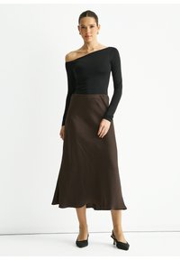 Black long-sleeve top with an off-shoulder design, paired with a brown ankle-length skirt made of smooth fabric, featuring a slight A-line silhouette.