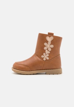Braune flache Stiefeletten aus Kunstleder mit dekorativen Blumen- und Herz-Applikationen an der Seite sowie einer Schlaufe hinten.