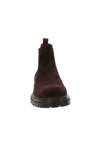 Bruine suède enkelboot met een zwarte rubberen zool, elastische zijkanten en een trekloop met een rode accent. Gladde textuur, gestroomlijnd ontwerp.