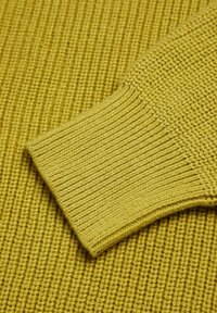 Maglione lavorato a maglia di un giallo vivace, con polsini a coste e un corpo testurizzato con un motivo uniforme in tutto.