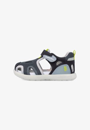 Sandalia de niño en azul marino y gris con puntera abierta, tejido de malla, tira de Velcro con la etiqueta "biomecanics" y suela de goma blanca.
