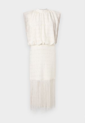 White dress with a textured design, shoulder pleats, elastic waist, and fringe detail at the hem, creating a flowing silhouette.