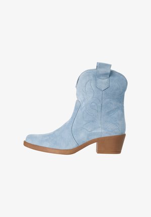 Jasnoniebieski zamszowy kowbojski but za kostkę z ozdobnym przeszyciem, pętelką do zakładania, jasnobrązowym niskim obcasem oraz zaokrąglonym noskiem.