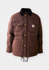 Chaqueta acolchada marrón con cuello de pana, cuatro bolsillos frontales, herrajes dorados y un cordón ajustable en el dobladillo.
