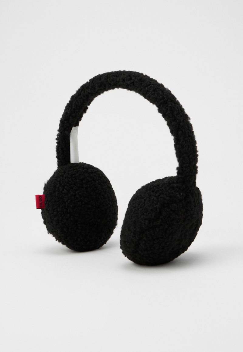Casque audio en peluche noir doux avec un bandeau rembourré et des écouteurs ronds. Présente une petite étiquette logo rouge d'un côté.
