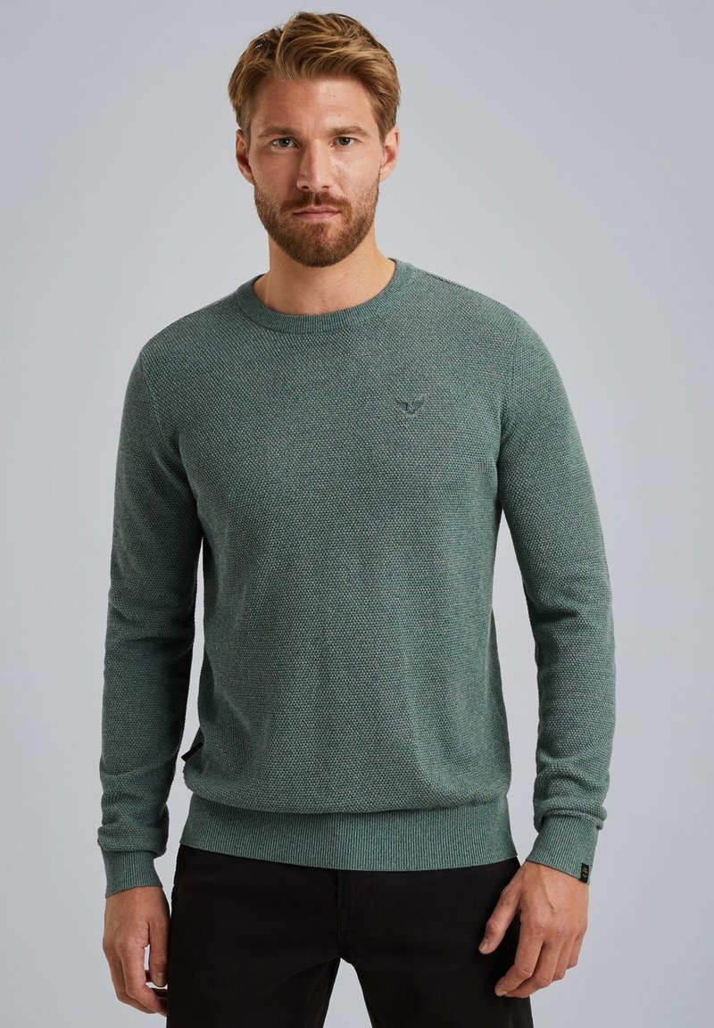 Pull en maille verte avec un motif texturé, manches longues, col rond et poignets et ourlet côtelés. Détail de petit logo sur la poitrine.