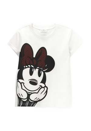 Biały t-shirt z krótkim rękawem z dużą czarno-białą kreskówkową twarzą z czerwonym kokardą z przodu, ręce pod brodą.