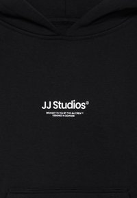 Hoodie noir en tissu doux, arborant un texte blanc : "JJ Studios," avec un texte supplémentaire en dessous. Design classique à enfiler avec capuche.