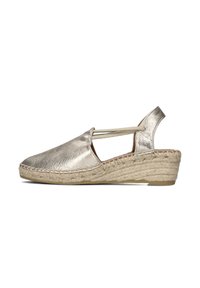Metallic gold espadrille wedge with a woven rope sole and elastic strap. Open design, smooth texture, and rounded toe.