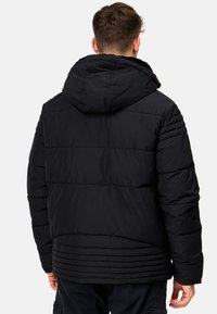 Schwarze Daunenjacke mit Kapuze, gestepptem Design, weicher Textur und gerippten Akzenten am unteren Rücken und an den Ärmeln.