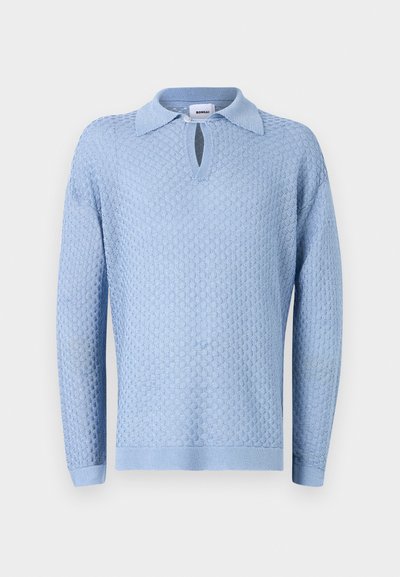 Lyseblå strikket genser med et teksturert mønster, polo-krage og en nøkkelhullsåpning ved halsen. Lange ermer og ribbede mansjetter.