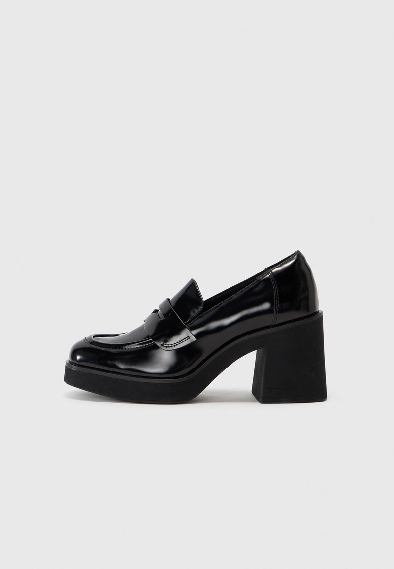 Mocassin en cuir noir brillant avec une semelle plateforme épaisse et un talon bloc haut, avec une bride sur le dessus.