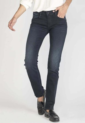 Donkerblauwe, slim-fit jeans van denim, met vijf zakken, vijf riemlussen en een lichte vervaging. Draagt met zwarte instappers.