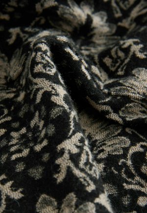 Black and beige patterned fabric with floral design, featuring a soft texture and intricate detailing. The material appears slightly fuzzy.