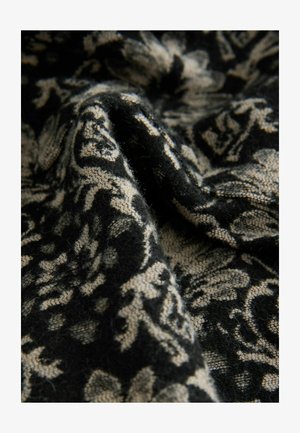 Černobéžová tkanina s květinovým vzorem, která má měkkou strukturu a složité detaily. Materiál vypadá mírně chlupatě.