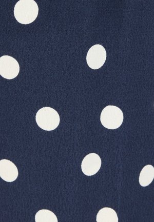 Navy blue fabric with scattered white polka dots of varying sizes and slightly textured surface.