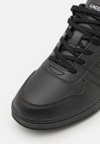 Czarne skórzane trampki z zaokrąglonym noskiem, teksturowanymi sznurowadłami i prążkowaną podeszwą. Subtelne detale przeszycia po bokach.