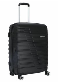 Black hardshell suitcase with ribbed texture, telescopic handle, and four dual-spinner wheels. Features a logo on the front.