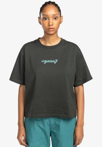 Black cotton short-sleeve t-shirt with a cropped design and turquoise skateboard graphic on the chest. Smooth texture, relaxed fit.