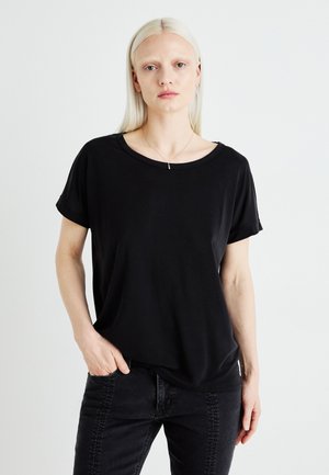 Black short-sleeve T-shirt with a relaxed fit, round neckline, and soft texture, paired with dark jeans. Simple, versatile design.