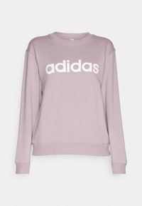 Světlý fialový svetr s kulatým výstřihem, dlouhými rukávy, žebrovanými manžetami a velkým bílým logem "adidas" vpředu.