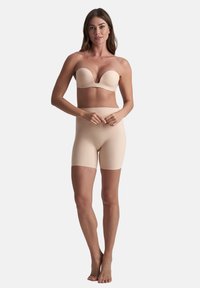 Nude strapless bh met een gladde, gevormde design; gecombineerd met hoge taille, strakke nude shorts, beide gemaakt van rekbare, zachte stof.