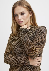 Langärmliges Oberteil mit einem geometrischen Muster in Gold und Schwarz, aus strukturiertem Stoff und mit gerafften Ärmeln.