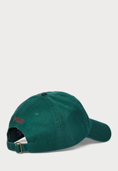 Zaļš kokvilnas beisbola cepure ar sarkanu izšuvumu "POLO". Izliektā mala, regulējama siksna ar zelta tonis sprādzi aizmugurē. Gluda tekstūra.